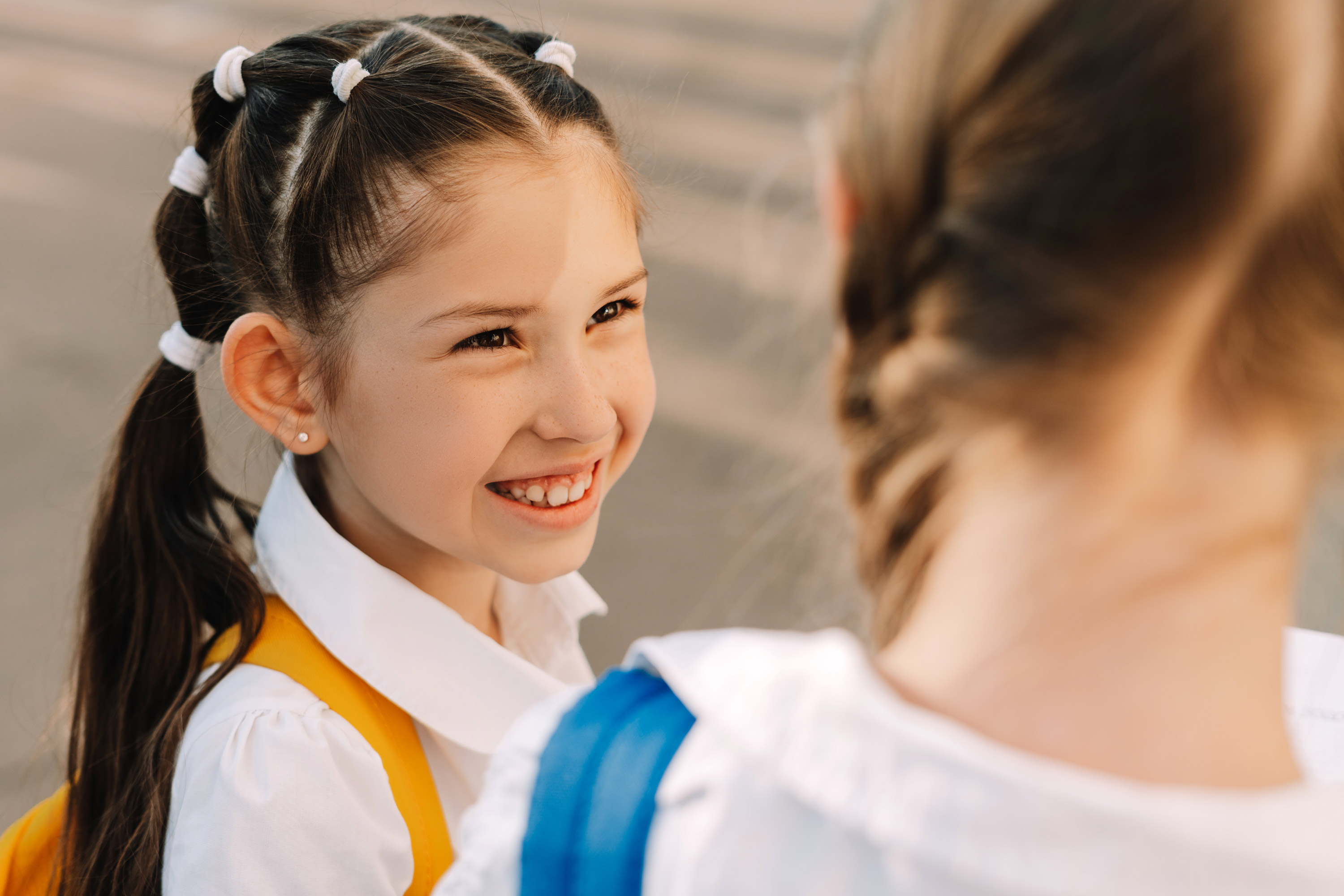 Girl With Backpack Smiling At Her Friend