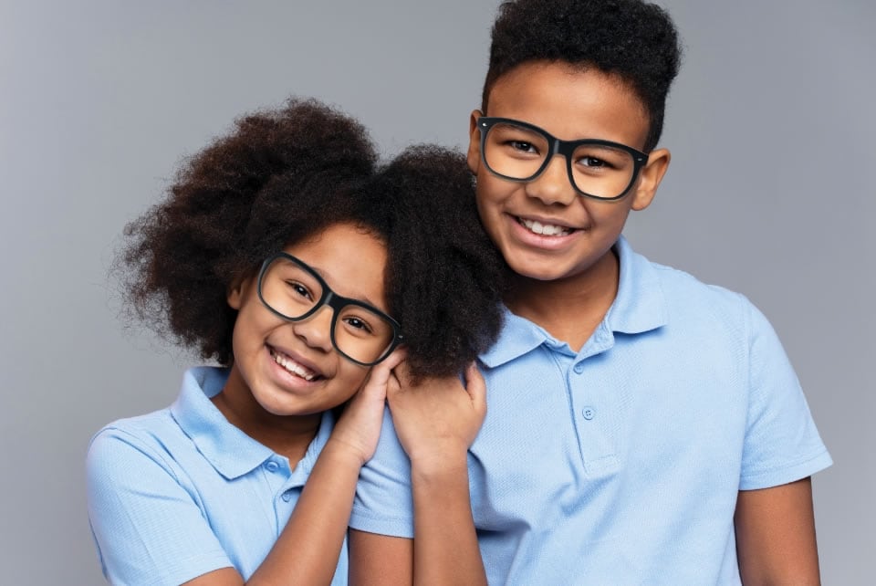 Boy and Girl Sibling leaning on eachother with glasses