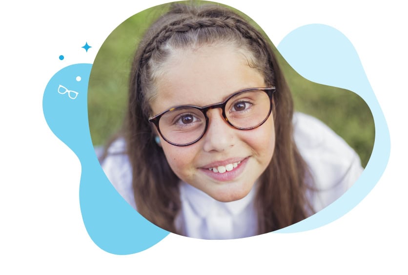 Girl staring up and smiling with glasses on grass