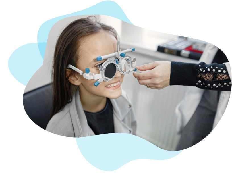 Girl using ophthalmoscope to test eyes in clinic
