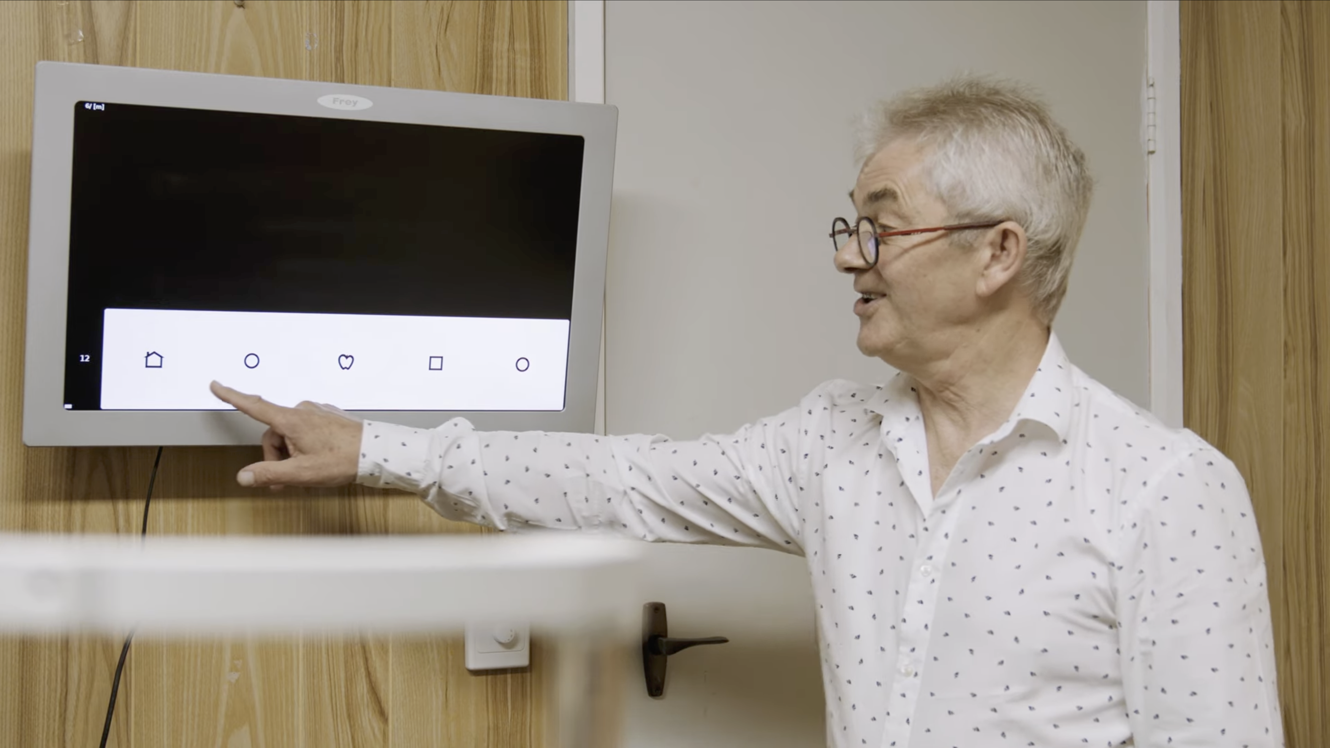 Clinic Doctor pointing at tv screen during eye test
