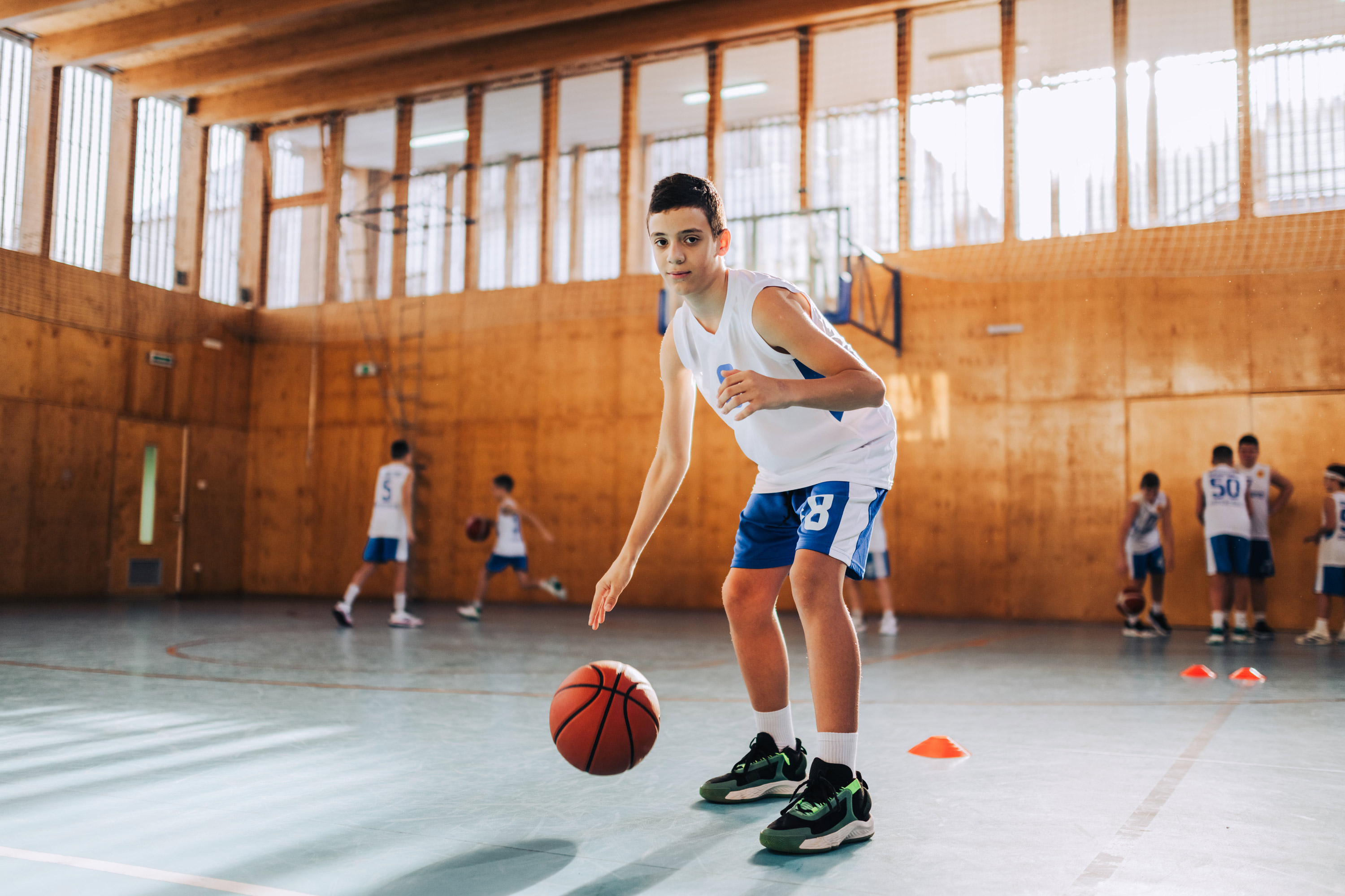 An Active Basketball Kid Is Practicing And Dribbling