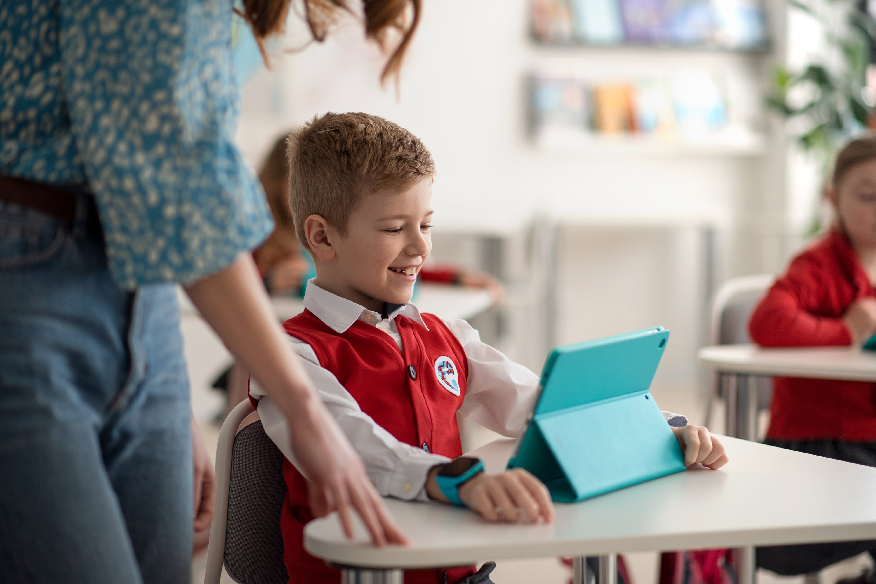 Happy Schoolboy Using Digital Tablet During Lesson