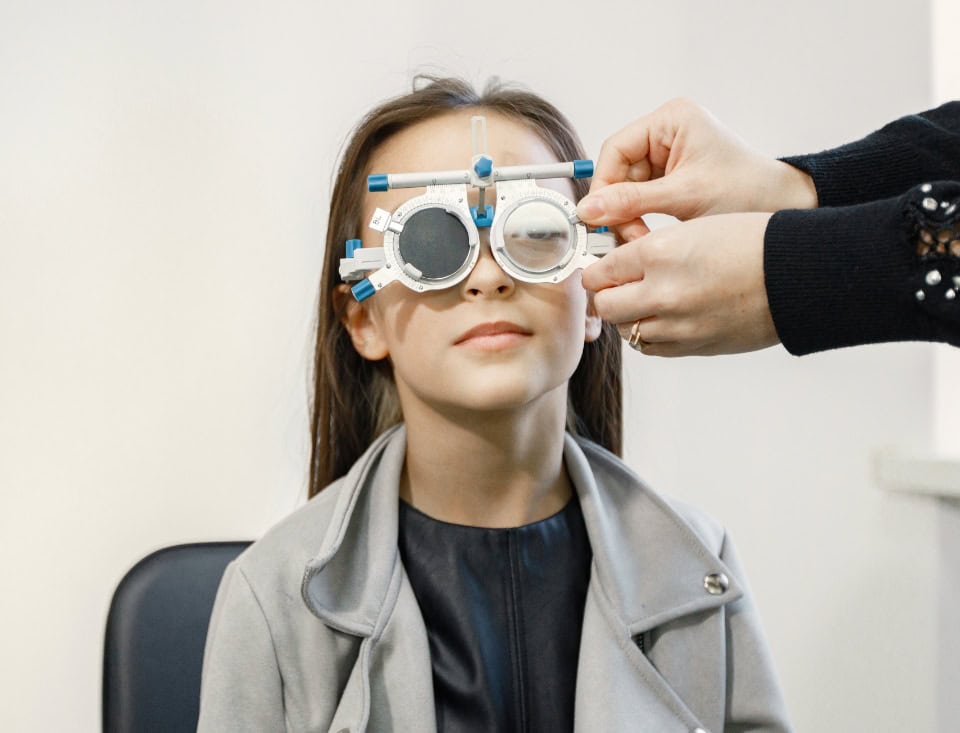 Little Girl Checking Up Her Sight Ophthalmology Center Female Optometrist Doing Sight Testing Brunette Girl Wearing Grey Jacket Black Shirt